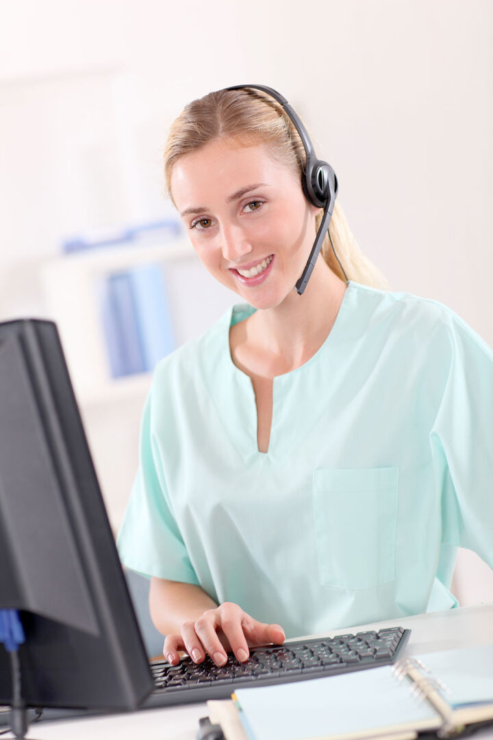 A woman wearing a headset and smiling for the camera.